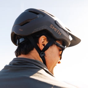 A man wears the Smith Pilot helmet on a white background.